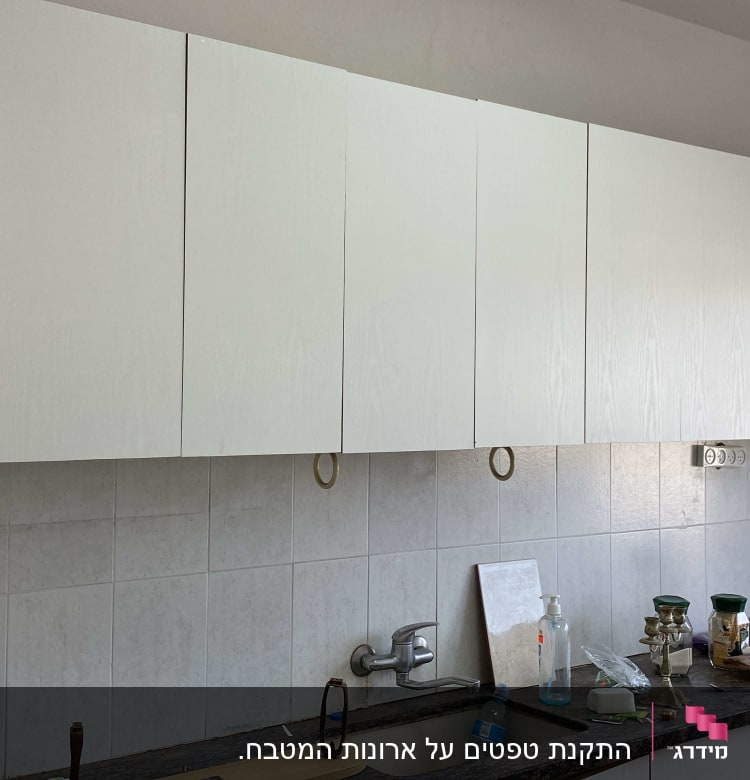 ארונות מטבח לבנים מעל כיור וברז